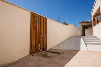a wooden door on the side of a building with stairs at Petra d'Oro Villa Palombaggia in Porto-Vecchio
