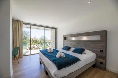 a bedroom with a large bed and a large window at Villa 20 in Sainte-Lucie de Porto-Vecchio