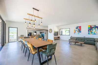 a dining room and living room with a table and chairs at Villa 20 in Sainte-Lucie de Porto-Vecchio