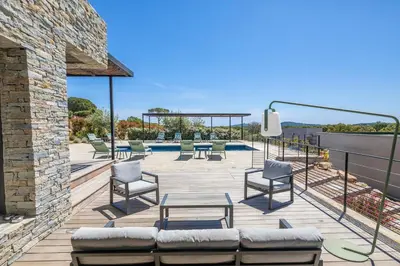 a patio with chairs and a table and a pool at Villa 20 in Sainte-Lucie de Porto-Vecchio