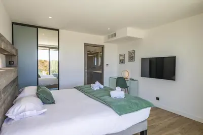 a bedroom with a large bed with a flat screen tv at Villa 20 in Sainte-Lucie de Porto-Vecchio