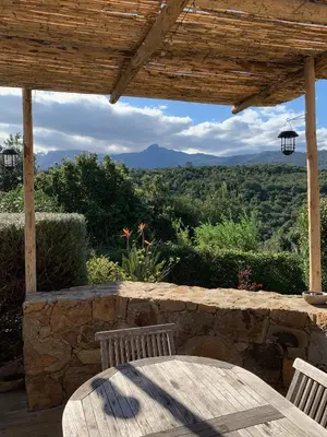 a table and chairs on a patio with a view at Villa Machja Solenzara in Sari Solenzara
