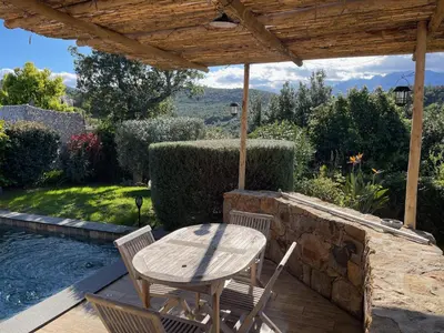 a wooden table and chairs on a wooden deck with a patio at Villa Machja Solenzara in Sari Solenzara