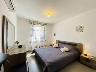 a bedroom with a bed and a desk and a window at PORTO PIANO 2 pièces au coeur de la ville in Propriano
