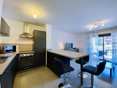 a kitchen with a counter and two bar stools at PORTO PIANO 2 pièces au coeur de la ville in Propriano