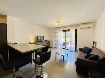a living room with a couch and a table at PORTO PIANO 2 pièces au coeur de la ville in Propriano