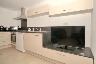 a kitchen with white cabinets and a flat screen tv at Studio Di Felicita in Cauro