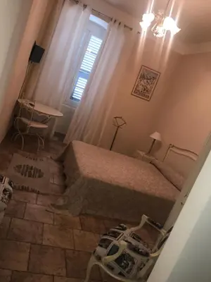a bedroom with a bed and a desk and a window at A Balamata in Cervione