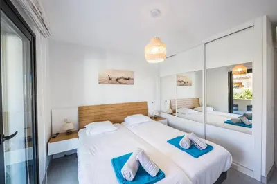 two beds in a room with two blue towels at Résidence Petra d'Oro - Villa Rondinara in Porto-Vecchio