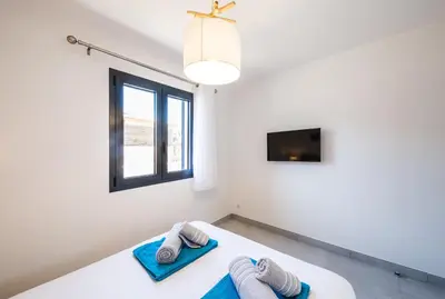 a bedroom with two towels on a bed with a window at Résidence Petra d'Oro - Villa Rondinara in Porto-Vecchio