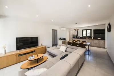a living room with a couch and a tv at Résidence Petra d'Oro - Villa Rondinara in Porto-Vecchio