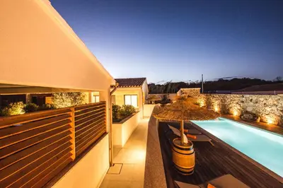 a patio with an umbrella and a swimming pool at Résidence Petra d'Oro - Villa Rondinara in Porto-Vecchio