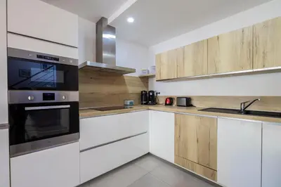 a kitchen with white cabinets and a stove top oven at Porto Vecchio Villa Bagatelle 8 personnes in Porto-Vecchio