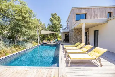 a pool with yellow lounge chairs next to a house at Porto Vecchio Villa Bagatelle 8 personnes in Porto-Vecchio