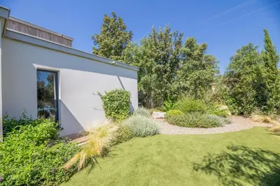 a garden with a white building and grass at Porto Vecchio Villa Bagatelle 8 personnes in Porto-Vecchio