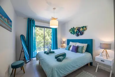 a bedroom with a blue bed and a window at Porto Vecchio Villa Bagatelle 8 personnes in Porto-Vecchio