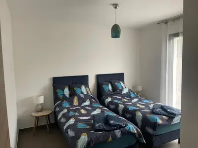 a bedroom with two beds next to a window at Résidence de Tourisme 5* Porto Vecchio in Porto-Vecchio
