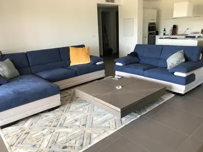 a living room with two blue couches and a coffee table at Résidence de Tourisme 5* Porto Vecchio in Porto-Vecchio
