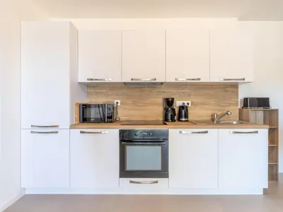 a kitchen with white cabinets and a counter with a microwave at Apartment St Joseph-1 by Interhome in Porto-Vecchio