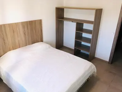 a bedroom with a white bed and a book shelf at A SUARA LINDA in Ghisonaccia