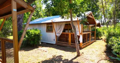 a small white building with a blue roof at Camping Merendella in San-Nicolao
