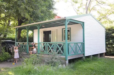 two children standing in front of a tiny house at Camping Merendella in San-Nicolao