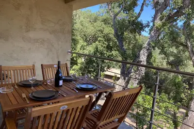 a wooden table with a bottle of wine on a balcony at L'Ortu Di Pisettu -1 in Conca