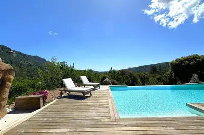 a deck with two chairs and a swimming pool at Villa Taglio Rosso Di Santa Lucia in Sainte-Lucie de Porto-Vecchio