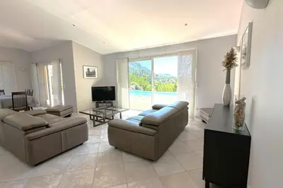 a living room with two couches and a television at Villa Taglio Rosso Di Santa Lucia in Sainte-Lucie de Porto-Vecchio