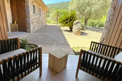 a porch with two benches and a view of a yard at Villa Taglio Rosso Di Santa Lucia in Sainte-Lucie de Porto-Vecchio