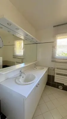 a bathroom with two sinks and a large mirror at Villa Taglio Rosso Di Santa Lucia in Sainte-Lucie de Porto-Vecchio