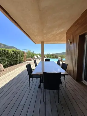 a wooden deck with a table and chairs on it at Villa Taglio Rosso Di Santa Lucia in Sainte-Lucie de Porto-Vecchio