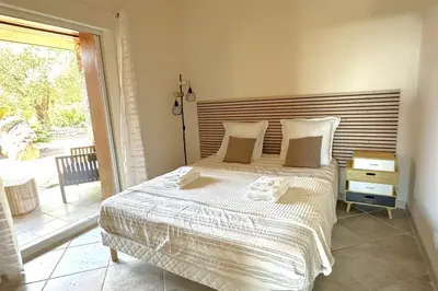 a bedroom with a bed and a large window at Villa Taglio Rosso Di Santa Lucia in Sainte-Lucie de Porto-Vecchio