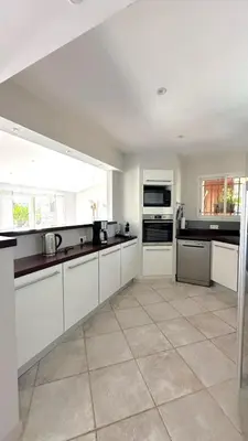a large kitchen with white cabinets and appliances at Villa Taglio Rosso Di Santa Lucia in Sainte-Lucie de Porto-Vecchio