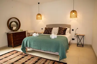 a bedroom with a bed with a mirror and a dresser at Les Villas de Palombaggia in Porto-Vecchio