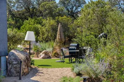 a garden with a piano in the middle of a yard at Les Villas de Palombaggia in Porto-Vecchio