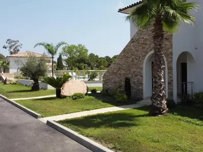 a palm tree in front of a building at Apartment A Suara Linda-1 by Interhome in Ghisonaccia