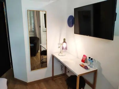 a room with a table and a television on a wall at Rosie's Club in Ajaccio