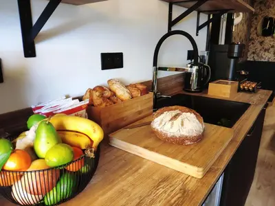 a counter with a bunch of fruit and a basket of bread at Rosie's Club in Ajaccio