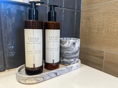 two bottles of wine sitting on a shelf in a bathroom at VILLA ISULA by Intendance Excellency in Sainte-Lucie de Porto-Vecchio