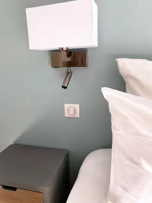 a lamp on a wall next to a bed at VILLA ISULA by Intendance Excellency in Sainte-Lucie de Porto-Vecchio