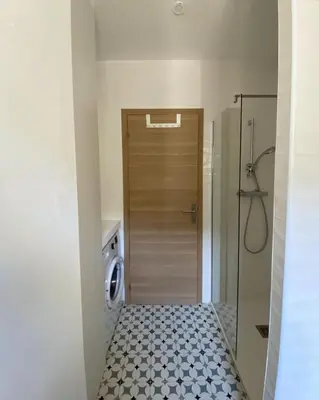 a bathroom with a door and a tile floor at Résidence Casarella Lama in Lama