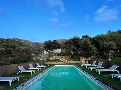 a swimming pool with white lounge chairs next to it at Résidence Casarella Lama in Lama