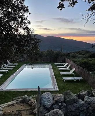 a swimming pool with lounge chairs in a yard at Résidence Casarella Lama in Lama