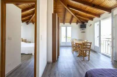 a room with a table and chairs and a bedroom at Terrasse de Malbeccu in Casamaccioli
