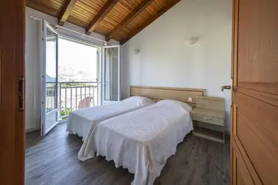 a bedroom with two beds and a large window at Terrasse de Malbeccu in Casamaccioli