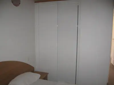 a bedroom with a closet with white walls and a bed at Terrasse de Malbeccu in Casamaccioli