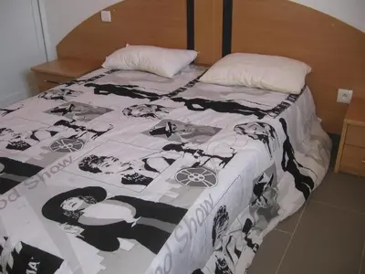 a bed with a black and white blanket with people on it at Terrasse de Malbeccu in Casamaccioli