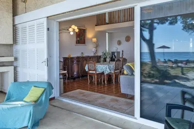 a living room with a sliding glass door to a dining room at Villa Les 3 frères in San-Nicolao