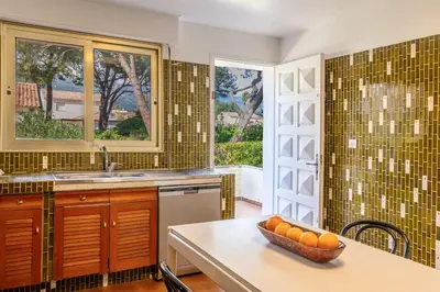 a kitchen with a table with a bowl of oranges on it at Villa Les 3 frères in San-Nicolao